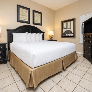Unwind in this inviting bedroom featuring a king bed, decorative artwork, and ample storage for your belongings