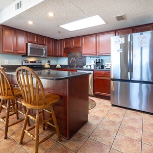 Kitchen featuring rich wooden cabinetry, granite countertops, and a breakfast bar with four wooden stools