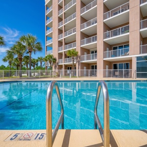 Dip into the sparkling pool surrounded by palm trees and lounge chairs, just steps from the beautiful beach view
