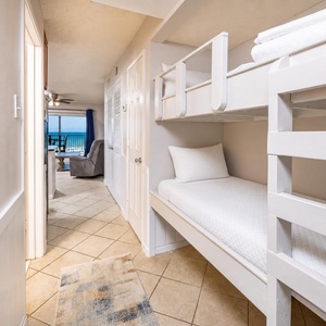 This cozy alcove features a built-in bunk bed, perfect for kids, with a view of the inviting living area and beach front