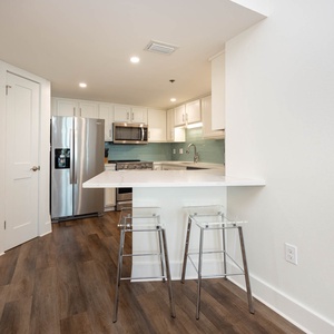 Gather around the sleek kitchen space with stylish seating, perfect for casual meals and conversation