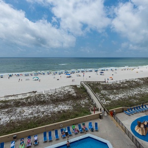Enjoy a vibrant view of the beach with colorful umbrellas and a lively pool area featuring a playful pirate ship splash park