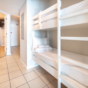 Two cozy bunks for kids can be found in the hallway, with easy access to the living space