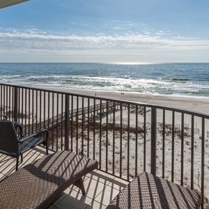 Relax on the balcony with comfortable seating, enjoying the tranquil views of the waves and beach below