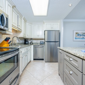 Prepare meals in the inviting kitchen featuring granite counters, stainless appliances, and elegant cabinetry