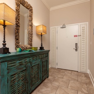 This welcoming entryway features a vibrant console, stylish lamps, and beach decor, setting a cheerful tone for your stay