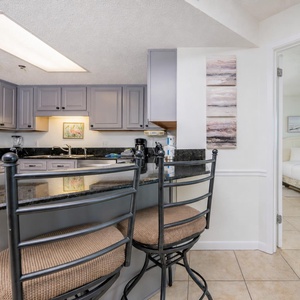 Modern kitchen with granite countertops, a breakfast bar with seating, and stainless appliances