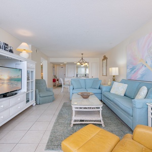 This living area features soft blue seating, a vibrant abstract painting, and a cozy atmosphere perfect for relaxation