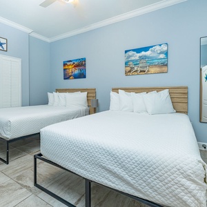 Relax on one of the cozy queen beds in this guest suite with charming coastal decor and enjoy a peaceful slumber