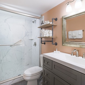 This bathroom features a stylish walk-in shower, elegant fixtures, and warm tones for a refreshing retreat