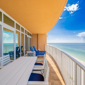 Savor the fresh air on the spacious balcony, featuring comfortable loungers and a dining area