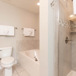 Indulge in relaxation in the master bath with a refreshing walk-in shower and soothing jetted tub, adorned with elegant tile