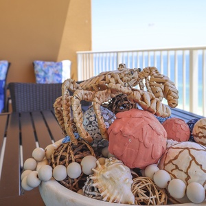 Fun crab design sitting on the balcony table filled with coastal accents adorns the charming vibe of this rental