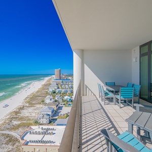 Enjoy expansive views from the spacious balcony, featuring stylish outdoor seating and a vibrant blue sky