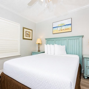 Rest in this tranquil guest bedroom featuring a comfortable queen bed, soft linens, and charming decor for a peaceful sleep