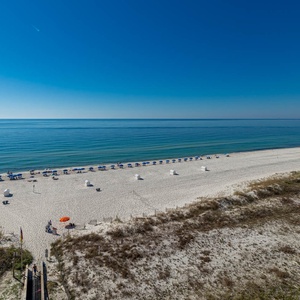 Gaze at the tranquil waters and beach chairs lined up, inviting you to relax and enjoy the serene coastal atmosphere