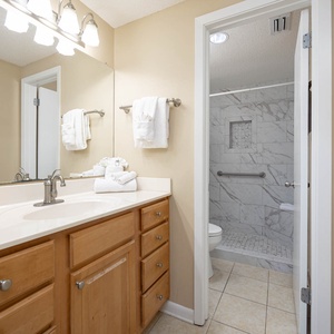 Refresh in this master bathroom featuring a spacious vanity, modern lighting, and a stylish tiled walk-in shower