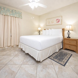 The inviting guest bedroom features a plush queen bed, warm lighting, and coastal-themed decor for a relaxing retreat