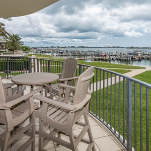 Lounge on the balcony with panoramic views overlooking the stunning bay water and marina activity