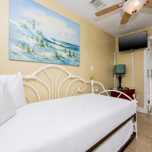 Cozy bedroom features a twin daybed with a twin trundle bed and TV, perfect for relaxation