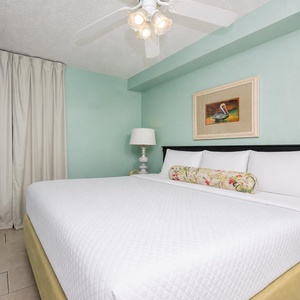 Retreat to this serene bedroom featuring a plush king bed, soft colors, and a TV for your entertainment