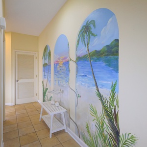 A vibrant mural of palm trees and a serene beach scene enhances the welcoming hallway, complemented by a white side table