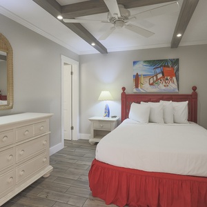 This guest bedroom features a vibrant red bed, stylish decor, and a cozy atmosphere perfect for relaxation