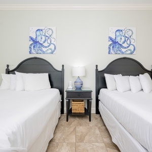 Relaxing guest bedroom featuring two comfortable queen beds and charming octopus artwork on the walls