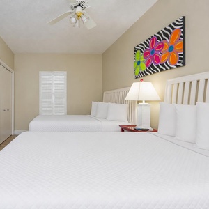 Relax in the guest suite with two queen beds while enjoying the vibrant artwork and unwinding after a beach day