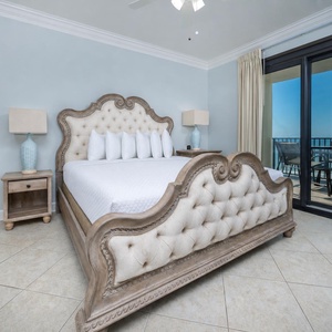 Elegant master bedroom featuring a plush king bed with decorative pillows, a stylish nightstand, and access to the balcony