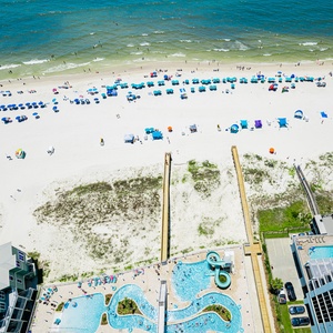 Discover the refreshing pool area with gradual entry, an inviting lazy river, and fun waterslide on the beach