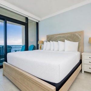 Relax in the master bedroom featuring a king bed, stylish decor, and beachfront balcony access