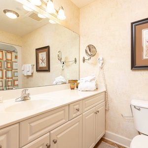 Indulge in your morning routine at this spacious vanity, surrounded by soft lighting and coastal decor