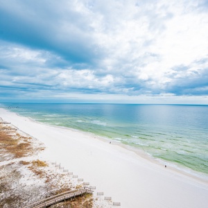 Gaze out at the expansive coast, where waves gently meet the shore, inviting you to explore the beach