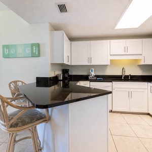 Prepare meals at the sleek black countertop, with easy access to the inviting kitchen and nearby dining area
