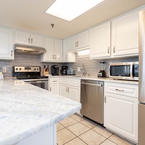 Kitchen featuring white cabinetry, a spacious countertop, stainless appliances, Keurig and a coffee maker