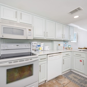 Spacious kitchen featuring modern appliances, white cabinetry, coffee maker, and a cozy vibe perfect for family meals
