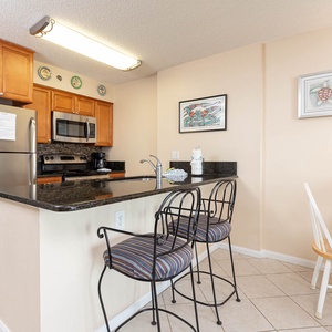 This kitchen features rich wood cabinetry, sleek stainless appliances, and a cozy breakfast bar perfect for morning coffee