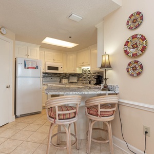 Gather around the breakfast bar with stylish seating, perfect for enjoying meals in this charming kitchen space