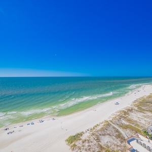 Stunning area view with soft white sands and gentle waves under a clear blue sky, perfect for a relaxing getaway