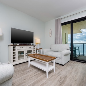 This inviting living area features a large TV, cozy seating, queen spfa-sleeper, and a breathtaking view from the balcony