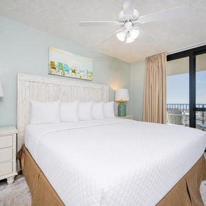 Calm hues and gentle lamps create a serene master suite with a king bed and balcony access to coast views