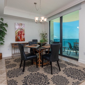 Dine in style at the round table with plush chairs, surrounded by vibrant decor and expansive views through large windows