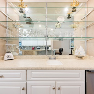 Enjoy preparing refreshing drinks at the sleek wet bar, surrounded by curated coastal decor and glassware