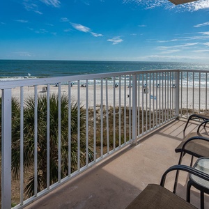 Enjoy breathtaking beachfront views from this balcony, featuring comfortable seating for relaxation and unwinding