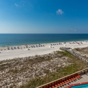 A stunning beachfront view showcases vibrant umbrellas on the white sand, inviting guests to relax by the tranquil waters