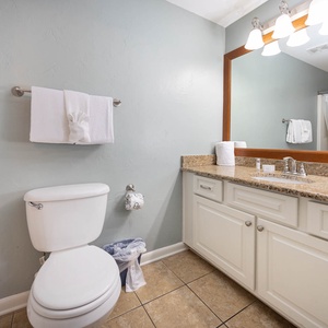 Experience the guest bathroom with a granite countertop, ample storage, and bright lighting for your comfort