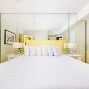 Spacious bedroom with king bed and beach decor, perfect for relaxing after a day at the beach