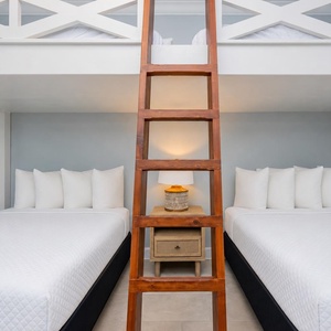 Discover a cozy loft bunk room with four double beds and soft lighting