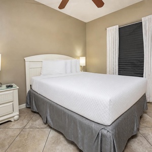 Rest comfortably in the serene guest bedroom with a queen bed, soft lighting, and elegant decor for a restful stay